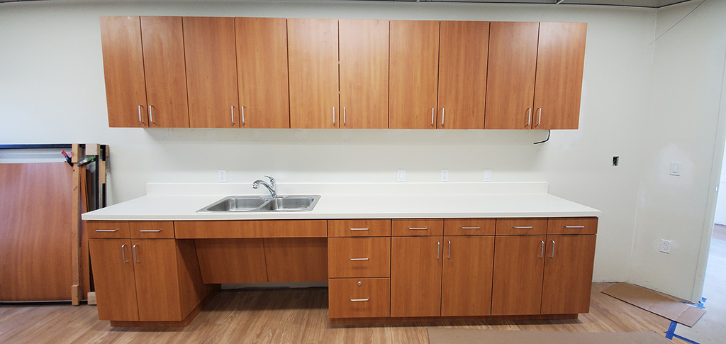 A wide counter at a medical clinic with dark wooden cabinets above and below.