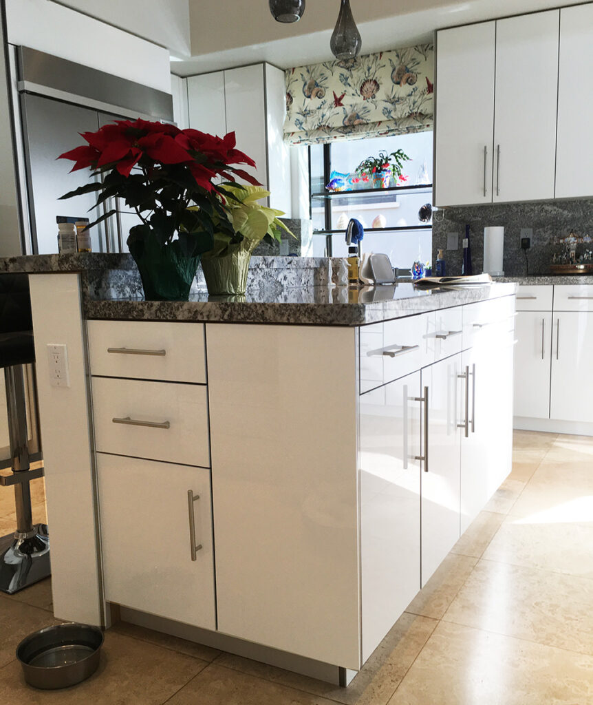 Interior kitchen remodel with glossy white cabinets and drawers, low angle of kitchen island.